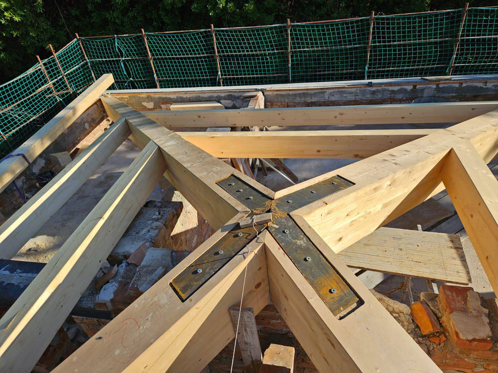 Lavoro di ristrutturazione di un tetto con travi in legno come struttura portante rinforzata con placche in metallo